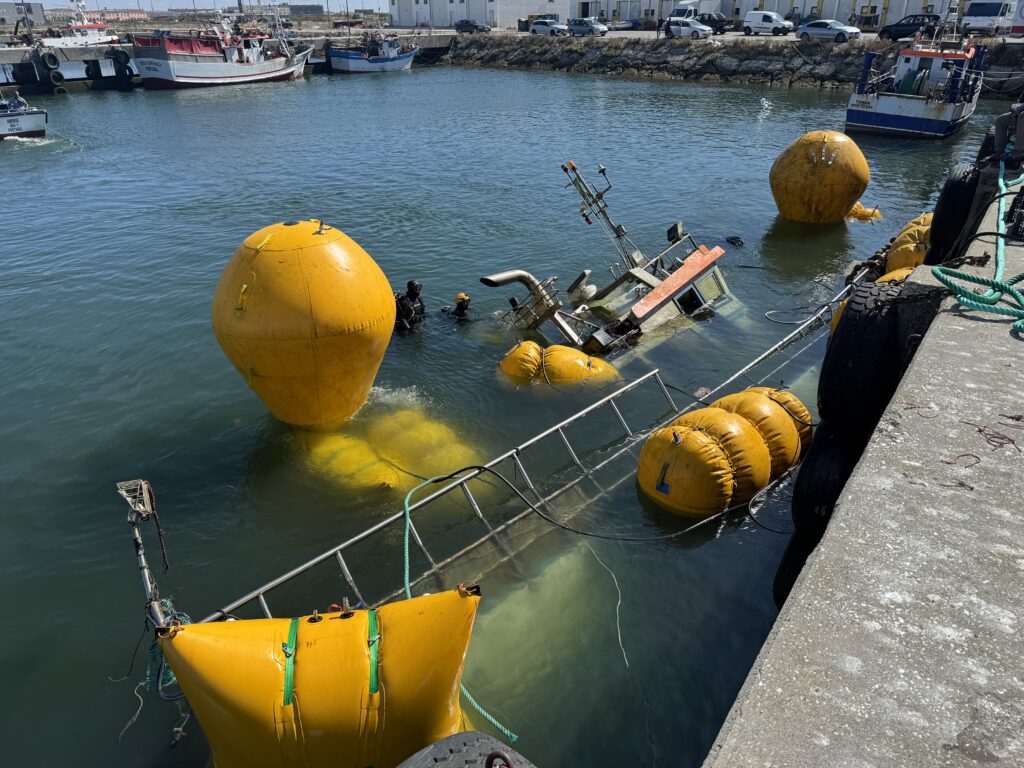 The Amuras half submerged, surrounded by lift bags rigged along the hull